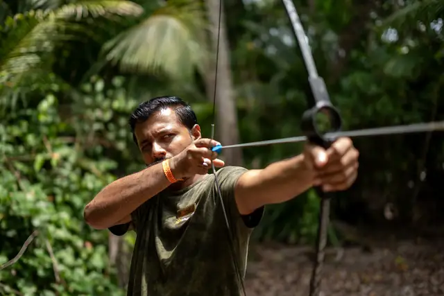 A Nomadic Tribes guide aiming a bow during an Archery session, Havelock Island
