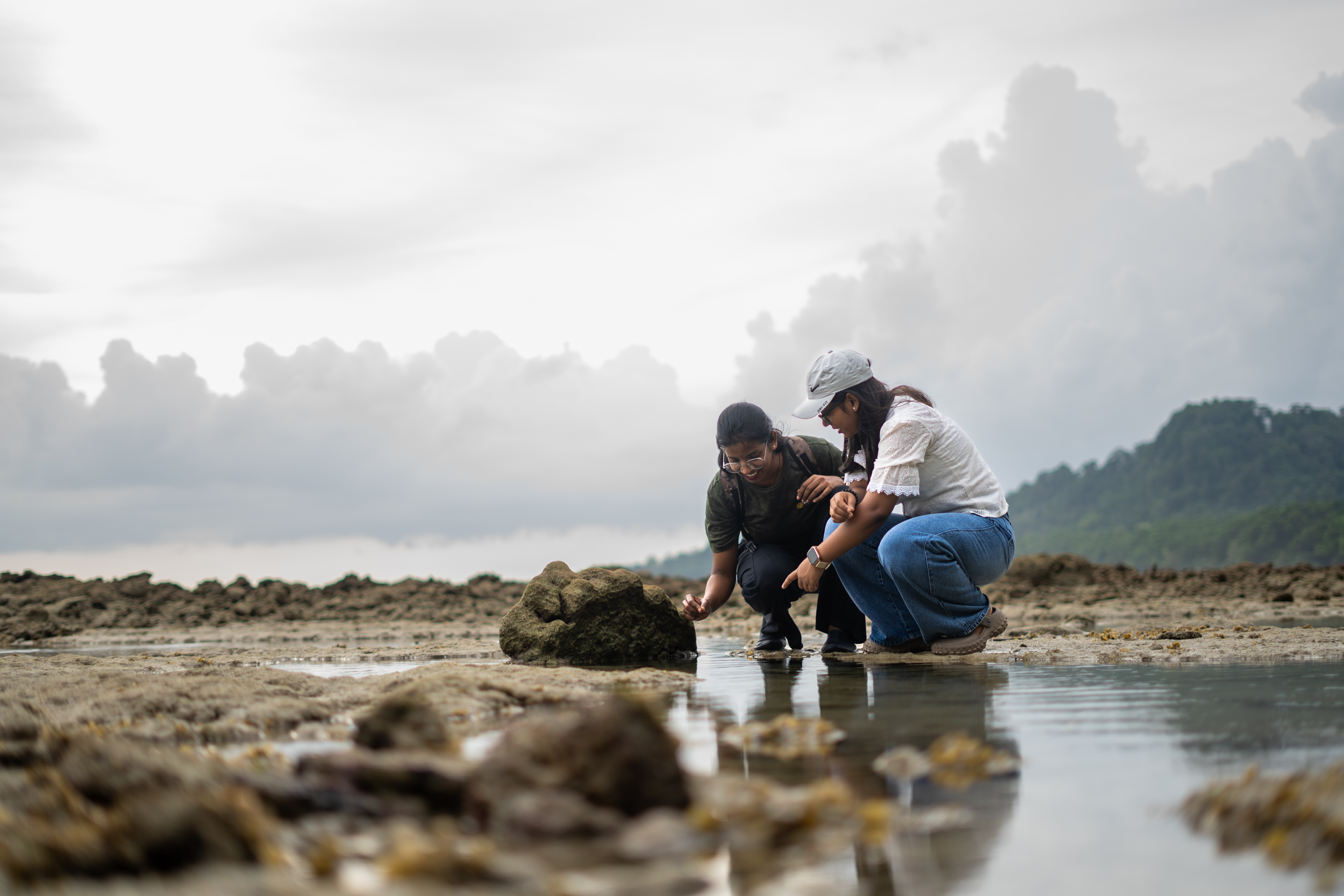 Two guests examining marine life in a tide pool during the Intertidal Walk, Havelock Island